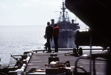 Flight deck crewmen aboard the amphibious assault ship USS SAIPAN (LPH-2) take a break as they watch U.S. and Spanish ships perform maneuvering exercises. The ships are taking part in exercise Ocean Venture '81