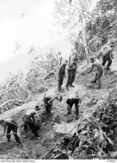 Aitape, New Guinea. 1944. Australian engineers hacking a road out of a mountain-side with pick and shovel