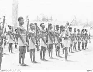 LAE, NEW GUINEA, 1944-03-25. RECRUITS IN THE PAPUAN INFANTRY BATTALION COMPOUND AT THE AUSTRALIAN NEW GUINEA ADMINISTRATIVE UNIT UNDER DRILL INSTRUCTION FROM SERGEANT KARI MM (1) WHO WAS DECORATED ..