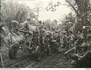 AITAPE AREA, NORTH EAST NEW GUINEA. C. 1944-04-22. PROTECTIVE ACK-ACK MOVES THROUGH THE JUNGLE HAULED BY A UNIT OF THE RAAF MOBILE WORKS PERSONNEL WHILE AMERICAN GUN CREWS RIDE WITH THEIR ANTI ..