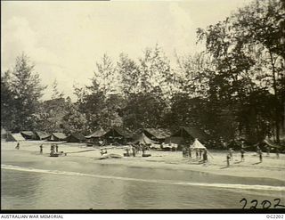 BOUGAINVILLE ISLAND, SOLOMON ISLANDS. C. 1945-01-25. ON THE BEACH GREEN-CLAD AUSTRALIAN MILITARY FORCES TROOPS EAGERLY AWAIT THE MAILBAGS AS THEY DROP FROM THE ANSON AIRCRAFT OF NO. 10 ..