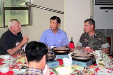 Lieutenant General Frank Libutti, (right), Commanding General, Marine Forces Pacific, Camp H. M. Smith, Hawaii, Lieutenant General George R. Christmas (Ret), (left), and Lieutenant General Lee, Republic of Korea Marine Corps (Ret) sit down for a luncheon during Exercise ULCHI FOCUS LENS 2000, Palan, South Korea. "ULCHI FOCUS LENS, held since 1976, is a computer-simulated, command-post exercise held to evaluate and improve operations in the defense of South Korea. There is no field training."