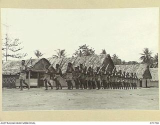 LAE, NEW GUINEA, 1944-03-25. RECRUITS IN THE PAPUAN INFANTRY BATTALION COMPOUND AT THE AUSTRALIAN NEW GUINEA ADMINISTRATIVE UNIT RECEIVE DRILL INSTRUCTION FROM SERGEANT KARI MM, WHO WAS DECORATED ..