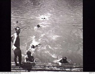 DONADABU, NEW GUINEA. 1943-11-09. TROOPS OF THE 7TH AUSTTRALIAN INFANTRY BRIGADE SIGNALS SECTION AND BATTERY SIGNALS PLATOONS HOLDING AN IMPROMPTU SWIMMING CARNIVAL IN THE LALOKI RIVER. SHOWN: ..