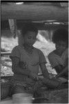 Food preparation: woman mashing taro with a wooden beater