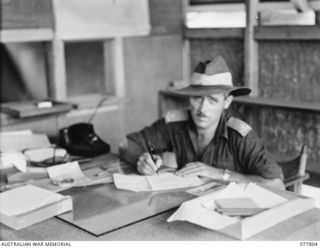 LAE BASE AREA, NEW GUINEA. 1944-12-27. NX108957 MAJOR R.B.S. HISLOP, OFFICER- IN- CHARGE, WORKING IN HIS OFFICE AT THE 13TH WORKSHOPS AND PARK COMPANY