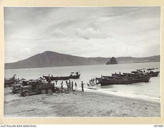 BLANCHE BAY, RABAUL, NEW BRITAIN. 1945-10-03. JAPANESE TROOPS UNLOADING JAPANESE ARMS AND AMMUNITION FROM TRUCKS AT THE BARGE POINT. THESE WILL BE DUMPED AT SEA UNDER 28 INFANTRY BATTALION ..