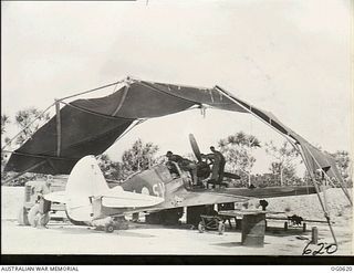 KIRIWINA, TROBRIAND ISLANDS, PAPUA. 1944-01-31. RIGGERS AND FITTERS WORKING ON A KITTYHAWK AIRCRAFT OF NO. 76 SQUADRON RAAF UNDER A CANOPY ERECTED AS SHELTER FROM THE TROPICAL SUN