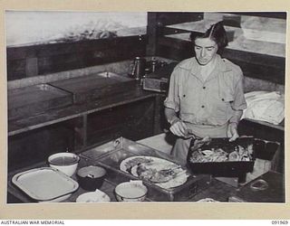 BOUGAINVILLE, 1945-04-19. WARRANT OFFICER 2 F.M. CHANDLER, DIET SUPERVISOR, AUSTRALIAN ARMY MEDICAL WOMEN'S SERVICE PREPARING SPECIAL DISHES AT 2/1 GENERAL HOSPITAL