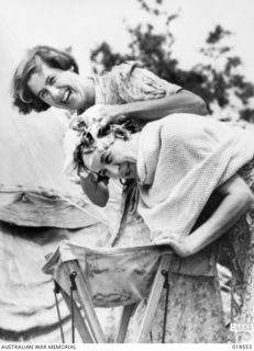 1943-04-01. AUSTRALIAN NURSES IN NEW GUINEA. HAIR SHAMPOO AND SETTING REMAINS IMPORTANT TO NURSES IN FORWARD AREAS. SISTER JOAN SANDISON OF GLENELG, SOUTH AUSTRALIA, GIVES A SHAMPOO TO SISTER ..