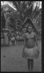 Woman in front of group and house