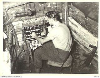 MOTUPINA POINT, BOUGAINVILLE ISLAND. 1945-01-19. VX142164 GUNNER E.G. PECK, 2ND FIELD REGIMENT, (1), OPERATING THE SWITCHBOARDS OF NO. 5 BATTERY, WHICH ARE A 6 AND 10 PLUG AND CARRY THE LINES FROM ..