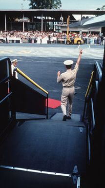 A recently released U.S. Navy Prisoner of War, one of the first group to be released by Hanoi, gives the "Peace sign" as he deplanes from a C-141 Starlifter during a refueling stop. The POWs were enroute from Clark Air Base, Philippines to Travis Air Force Base, CA and then to be reunited with their families in the states