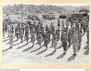 LAE AREA, NEW GUINEA, 1945-08-05. MEMBERS OF HEADQUARTERS AND WORKSHOP PLATOON, 151 GENERAL TRANSPORT COMPANY, PRESENT ARMS. THE MEN ARE ON PARADE DURING AN INSPECTION OF THE UNIT BY BRIGADIER P.S. ..