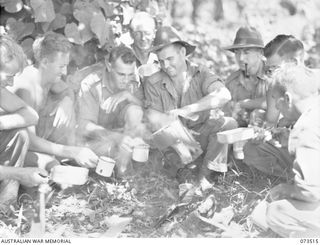 Members of the 35th Infantry Battalion boiling a 'billy' during a rest period from their march up the coast. Identified from left to right: NX120484 Private H. Batiste (1); NX125624 Private R. G. ..