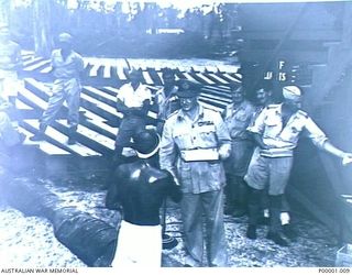 THE SOLOMON ISLANDS, 1945-01-12. A NATIVE BEING CONGRATULATED AND PRESENTED WITH A PRIZE AT A COMBINED ANZAC SPORTS MEETING AT BOUGAINVILLE ISLAND. (RNZAF OFFICIAL PHOTOGRAPH.)