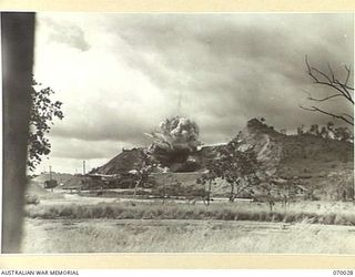 NINE MILE QUARRY AREA, PORT MORESBY, NEW GUINEA. 1944-01-22. THE 12TH COMMANDER ROYAL ENGINEERS, (WORKS), (A.I.F.), FIRING A 350 LB CHARGE OF GELIGNITE AND MONOBELL AT THE NINE MILE QUARRY. THE ..