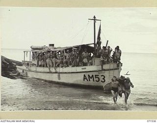 SINGORKAI, NEW GUINEA. 1944-03-19. QX55306 LIEUTENANT C. E. BISHOP (1), BEING GIVEN A LIFT ASHORE FROM THE AM53 KAURI FOR A FOURTEEN DAY PATROL IN THE AREA AROUND SINGORKAI. NATIVE BOYS OF THE ..