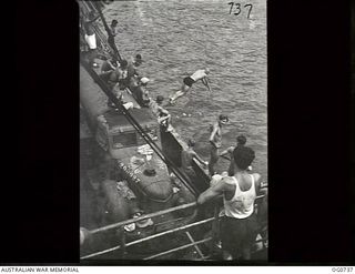 MILNE BAY, PAPUA. C.1944-02. AIRMEN FROM NO. 75 SQUADRON RAAF DIVING INTO MILNE BAY TO COOL OFF WITH A SWIM WHILE THEIR SHIP IS WAITING FOR CONVOY TO LAE. NOTE THE RAAF TRUCK (200927) ON THE DECK