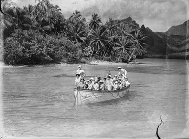 [People in a small boat being towed past a tropical island]