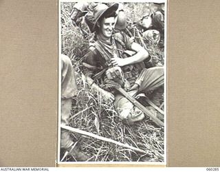 RAMU VALLEY AREA, NEW GUINEA. 1943-11-08. SX30668 PRIVATE R. J. HILLIER OF GAWLER, SA, AND OF THE 2/27TH AUSTRALIAN INFANTRY BATTALION ENJOYS A SPELL DURING THE TREK FROM GUY'S POST