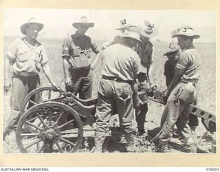 NADZAB AREA, NEW GUINEA. 1944-09-15. PERSONNEL OF THE 2ND MOUNTAIN BATTERY ASSEMBLING THEIR 75MM GUN. HERE THE FRONT TRAIL, IS BEING FITTED TO THE AXLE AND THE REAR TRAIL IS BEING FITTED INTO ..