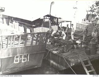 JACQUINOT BAY, NEW BRITAIN. 1944-12-01. TROOPS WORKING ON THE MAINTENANCE AND SPARE PARTS BARGE OF B COMPANY, 594TH ENGINEER BOAT AND SHORE REGIMENT, UNITED STATES ARMY AT THE MALMAL MISSION