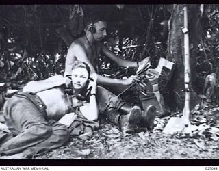 PAPUA, NEW GUINEA, 1942-10. 25TH AUSTRALIAN INFANTRY BRIGADE SIGNALS OFFICE AT BRIGADE HEADQUARTERS IN THE THICK JUNGLE AT NAURO. THE SIGNALS OFFICE WAS A LEAFY LEAN-TO BESIDE A JUNGLE TREE