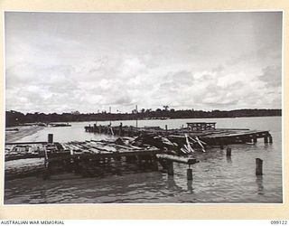 BUNA BEACH, NEW GUINEA. 1945-10-13. THE CRUMBLING WHARVES THREE YEARS AFTER THE TIDE OF WAR HAD PASSED THE BUNA-GONA AREA