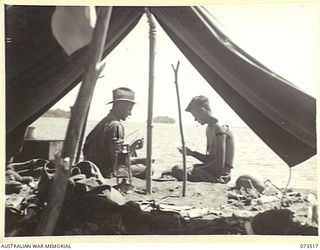 SARANG, NEW GUINEA. 1944-05-25. NX125641 LANCE-CORPORAL E.J. PASSFIELD (1), AND NX125639 PRIVATE A.C. SOUTH (2), ENJOY A QUIET GAME OF CARDS AT THE COAST LINE OUTSIDE THEIR TENT