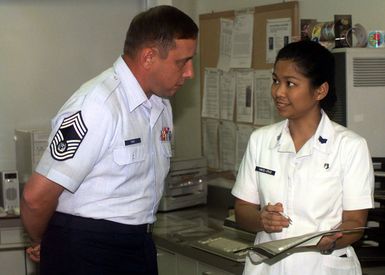 Right side profile medium close-up from the waist up of the CHIEF MASTER Sergeant of the Air Force Jim Finch as he speaks with STAFF Sergeant Vince-Cruze of the 15th Medical Squadron during his visit at Hickam Air Force Base, Hawaii