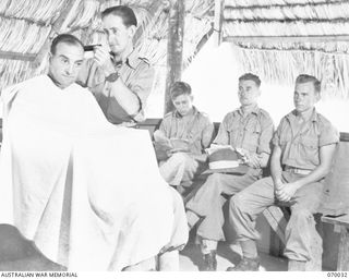 PORT MORESBY, NEW GUINEA. 1944-01-22. THE INTERIOR OF THE BARBER'S SHOP, BUILT BY THE 2/101ST GENERAL TRANSPORT COMPANY, IN OPERATION IN THEIR CAMP AREA. THE SHOP WAS EQUIPPED BY THE AUSTRALIAN ..