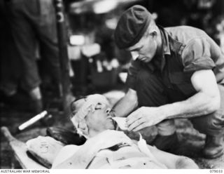 TSIMBA RIDGE, BOUGAINVILLE ISLAND. 1945-02-06. QX130750 "PADRE" JOE CHARLES, SALVATION ARMY (2), GIVING A DRINK TO NX179089 PRIVATE A.C. SMITH, NO 10 PLATOON, "B" COMPANY, 31/51ST INFANTRY ..