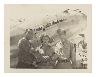 Pacific area, c. 1945. Judith Anderson (centre), an Australian-born stage and film actress, standing with two servicemen in front of an aircraft of the United States Army Air Force (USAAF) which ..
