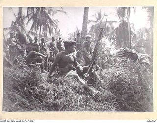 OINYALIB, NEW GUINEA. 1945-07-15. PRIVATE WUMBIER, 2 NEW GUINEA INFANTRY BATTALION, AN INTERESTED SPECTATOR AT A CONCERT PRODUCED BY MEMBERS OF NO. 5 DETACHMENT, FIRST ARMY ENTERTAINMENT UNIT, FOR ..