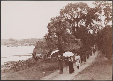 Missionaries and Melanesian women walking along track in Vila, New Hebrides, 1906 / J.W. Beattie