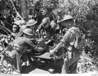 AITAPE, NORTH EAST NEW GUINEA. C. 1944-12-25. MEMBERS OF THE RAAF SIGNALS UNIT ASSEMBLING TRANSMITTER AND RECEIVING UNITS ON LANDING AT THE BEACH-HEAD