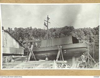 BALASANA, NEW GUINEA, 1943-07-06. NEW VESSEL NEARING COMPLETION AT THE SHIPYARDS OF THE 1ST AUSTRALIAN WATER TRANSPORT GROUP (SMALL CRAFT) MAINTENANCE BASE