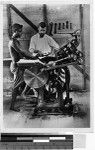 Priest showing a man how to use a printing press, Solomon Islands, Oceania, 1936