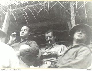 MILILAT, NEW GUINEA. 1944-08-31. BOB HOPE (1) AND JERRY COLONA (2) MEMBERS OF THE BOB HOPE CONCERT PARTY, WAITING BACKSTAGE FOR THEIR CUE DURING A CONCERT STAGED FOR ALLIED SERVICE PERSONNEL AT THE ..
