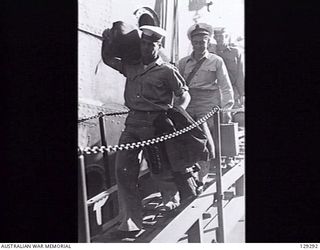 SYDNEY, NSW. 1946-05-09. ABLE SEAMAN A. FERGUSON, ONE OF THE NAVAL PERSONNEL RETURNING HOME, COMING DOWN THE GANGPLANK OF TROOPSHIP DUNTROON AFTER HER ARRIVAL AT CIRCULAR QUAY FROM KURE, MOROTAI ..