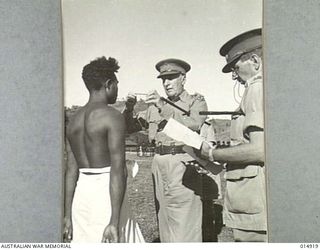 NEW GUINEA: GOVERNOR-GENERAL, LORD GOWRIE, VISITS NEW GUINEA. IN THIS PHOTO VARI GARI OF SARDA VILLAGE, NEAR BUNA, RECEIVES A MEDAL FOR HAVING SHOWN GREAT COURAGE IN ACTION WITH TWO AUSTRALIAN ..