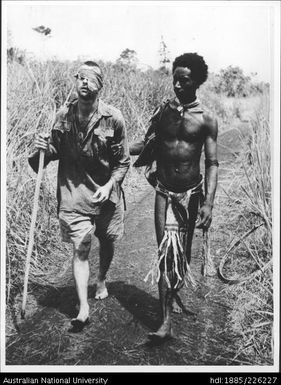 Papua New Guinean walking with an injured soldier