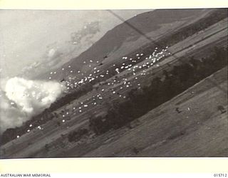 1943-09-15. ALLIED PARATROOPERS. AMERICAN AND AUSTRALIAN ARTILLERYMEN PARACHUTING TO THE MARKHAM VALLEY. THREE OF THE SCORES OF GIANT TRANSPORT PLANES WHICH WERE USED CAN BE OBSERVED. TO THE LEFT ..