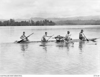 ALEXISHAFEN, NEW GUINEA. 1944-05-11. MEMBERS OF THE 30TH INFANTRY BATTALION PADDLE A NATIVE CANOE CARRYING DESPATCHES FROM HEADQUARTERS 30TH INFANTRY BATTALION TO HEADQUARTERS 8TH INFANTRY BRIGADE. ..