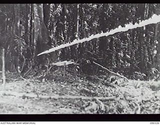 BOUGAINVILLE, 1945-04-04. A MEMBER OF THE FLAME THROWER PLATOON FROM 15TH INFANTRY BRIGADE, FIRING A MIAI PORTABLE FLAME THROWER USING OPERATIONAL FUEL. THIS EQUIPMENT WAS TAKEN OVER FROM AMERICANS ..