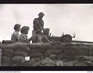 MOROBE, NEW GUINEA. 1943-08-13. PRACTICE SHOOT OF THE 40MM BOFORS GUN L3, 162 AUSTRALIAN LIGHT ANTI-AIRCRAFT BATTERY. LEFT TO RIGHT:- NX22047 SERGEANT R. H. TREASDALE; QX31930 GUNNER S. S. PLUMMER; ..