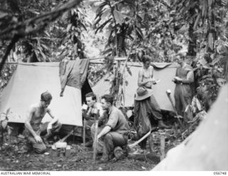 SALAMAUA AREA, NEW GUINEA. 1943-07-22. TROOPS OF THE 2/5TH BATTALION RESTING AT HEADQUARTERS, BUIGAP CREEK AFTER THE HEAVY FIGHTING IN THE MOUNT TAMBU AREA. LEFT TO RIGHT: VX41181 LANCE CORPORAL J. ..