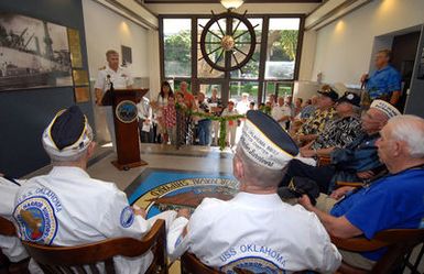 U.S. Navy CAPT. Frank J. Camelio, Commander of Pearl Harbor Naval Shipyard and Intermediate Maintenance Facility, delivers his remarks to USS OKLAHOMA survivors, seated, Ray Turpin, Jerry Tessaro, Paul Goodyear, George Smith, Raymond Richmond and James Bounds, during the Pearl Harbor Naval Shipyard's USS OKLAHOMA Lobby Display Dedication ceremony on Dec. 6, 2006, at Pearl Harbor, Hawaii. The renovation and dedication honors the historic tie between the Pearl Harbor Shipyard workers who aided in the rescue of 32 Sailors from the capsized ship in the days following Dec. 7, 1941. (U.S. Navy PHOTO by Mass Communication SPECIALIST 1ST Class James E. Foehl) (Released)