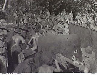 SAMPUN, NEW BRITAIN. 1944-12-27. TROOPS OF THE 14/32ND INFANTRY BATTALION UNLOADING ONE OF THEIR 2 POUNDER GUNS FROM A LANDING CRAFT MECHANISED